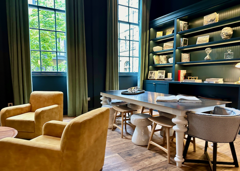 Cozy drawing room in a luxury hotel, with green velvet curtains and yellow armchairs.