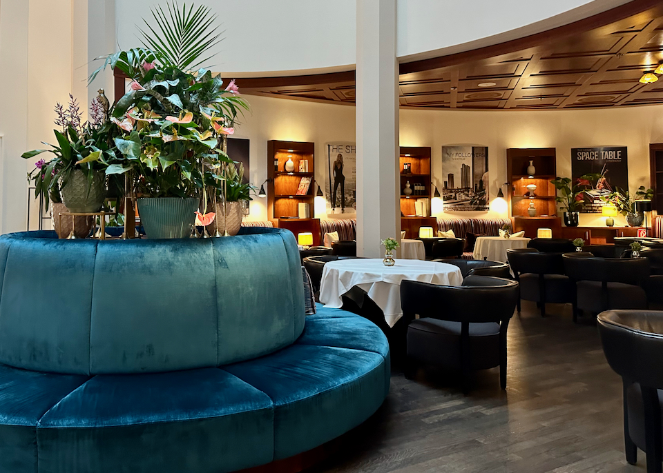 Hotel fine dining restaurant with teal velvet banquette seating