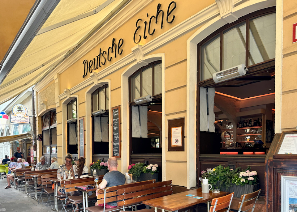 Exterior of a hotel, with restaurant tables in front.