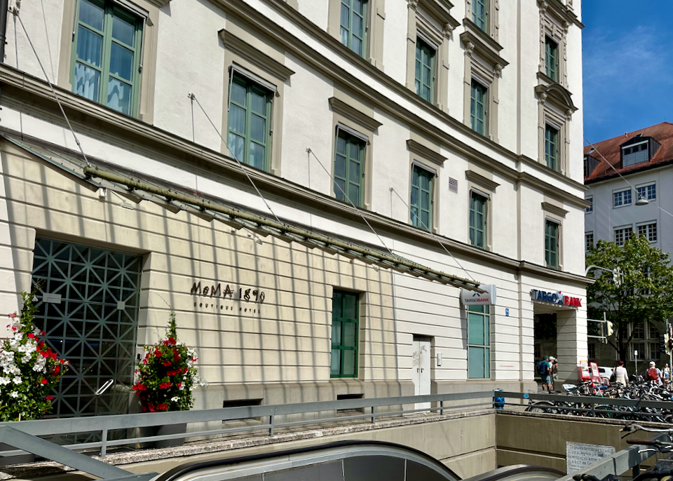 Exterior of a hotel, next to stairs heading down to a train station.