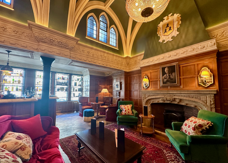 Warm and opulent hotel lounge with wood paneling and a large fireplace