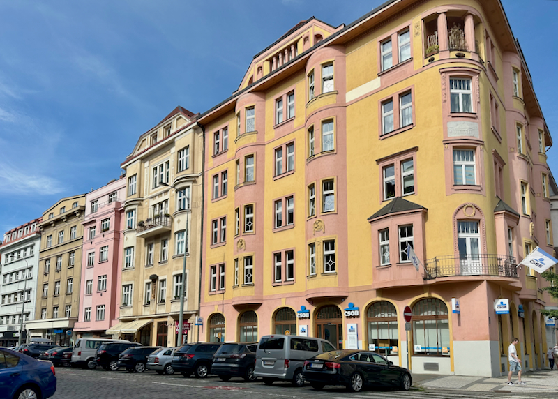 Pink and yellow buildings on a narrow street in Prague