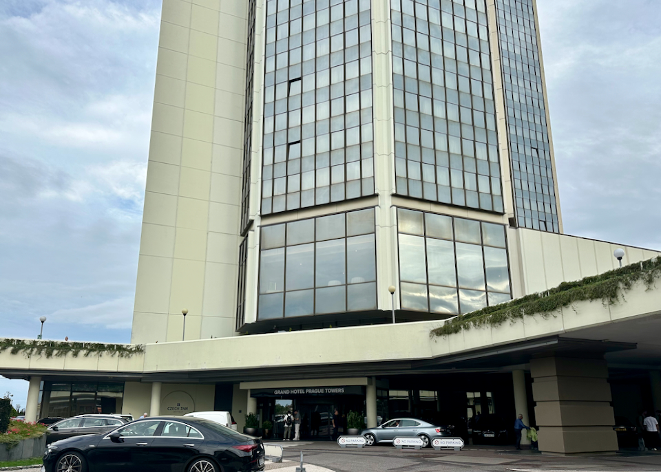 Circular drive and entrance to a modern glass tower-style hotel