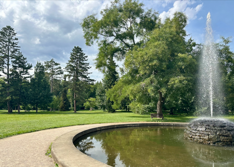 Round water fountain in the middle of a grassy green park