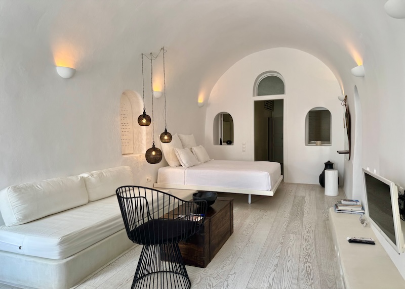 Contemporary white and black decor in a historic cave suite at 1864 The Sea Captain's House in Oia.
