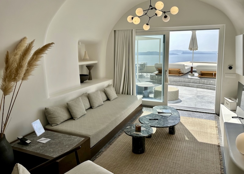 Inside a luxury cave suite in neutral colors with sun terrace and view of the caldera at Canaves Oia Suites.