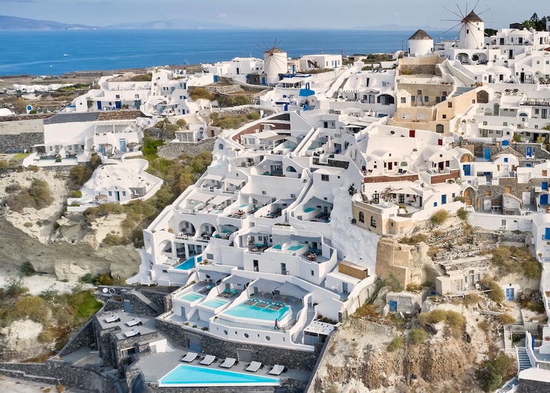 Aerial view of a Charisma, a cave hotel built in multiple levels down the side of the caldera in Oia, Santorini.