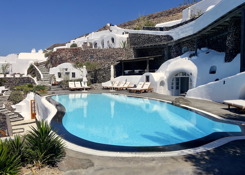 A freeform infinity pool with cave suites built into the caldera above at Perivolas hotel in Oia.