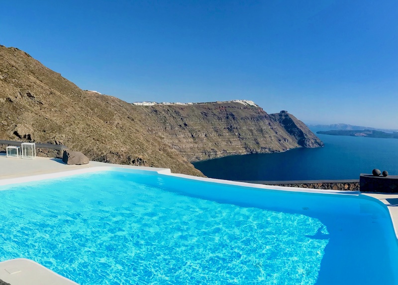 Infinity pool with a caldera view toward Skaros Rock and the volcanoes at Aenaon Villas in Santorini.