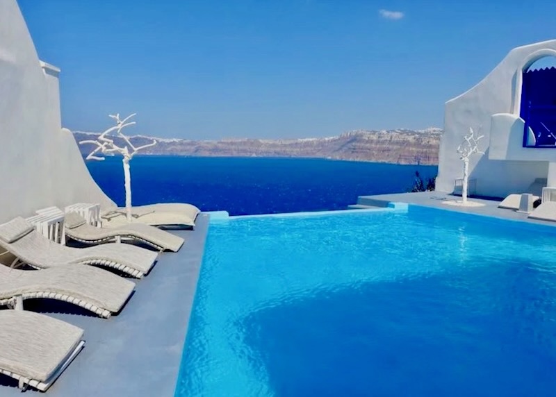 Infinity pool facing the caldera with sunbeds on each side at Astarte hotel in Santorini.