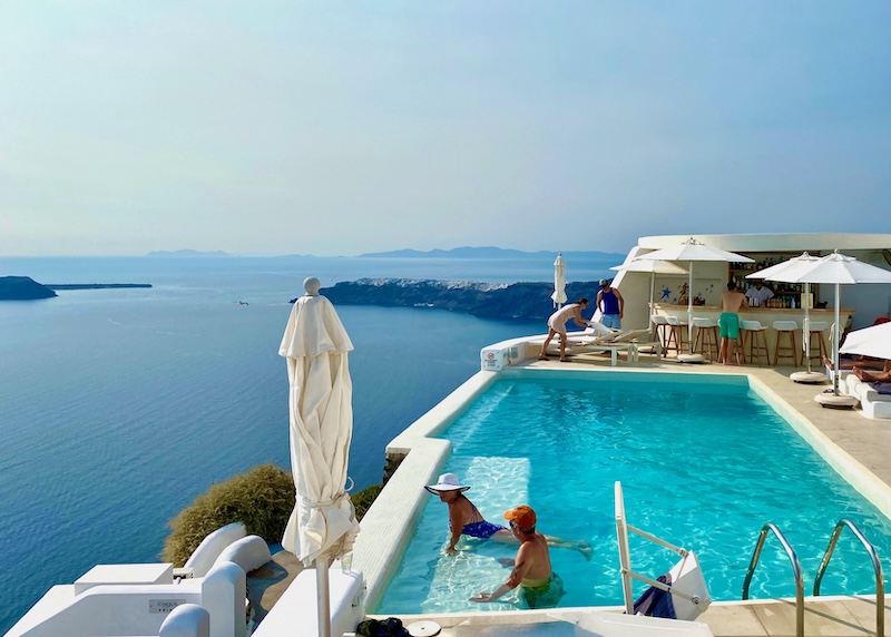 People enjoying the pool with caldera views at Astra Suites in Imerovigli.