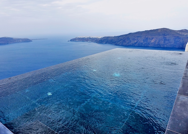 Infninty pool with a view toward Oia village and the caldera at Galaxy Suites in Santorini.