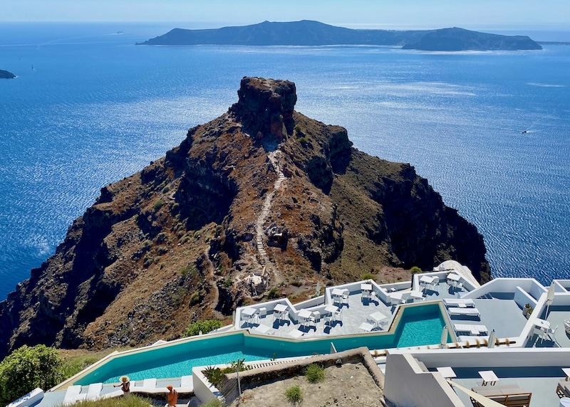 View down toward the infinity pool at Grace Hotel with Skaros Rock, the caldera, and Thirassia Island in the background in Santorini.