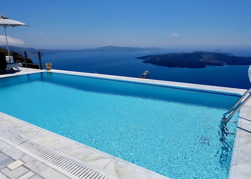 Infinity pool with a caldera view toward the volcanoes and Akrotiri in Santorini.