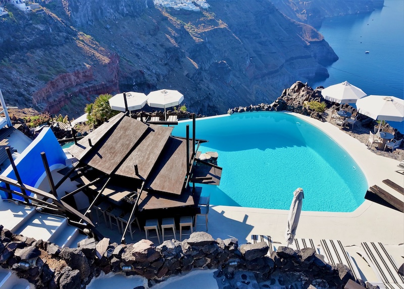 An infinity pool and bar overlooking the caldera at Honeymoon Petra hotel in Santorini.
