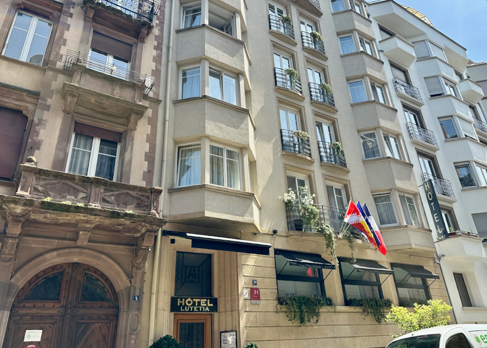Exterior of a hotel entrance with French Flags displayed.