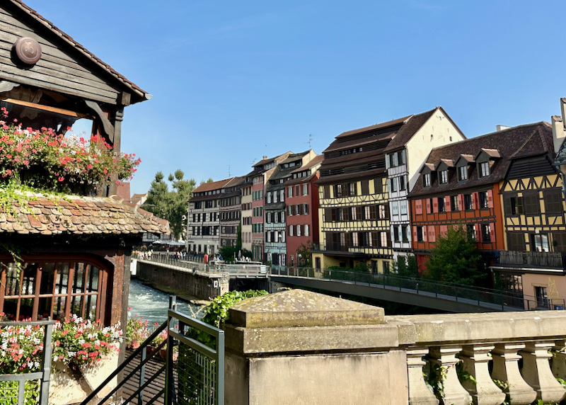 View down a river canal lined with colorful Alsacien timbered homes.
