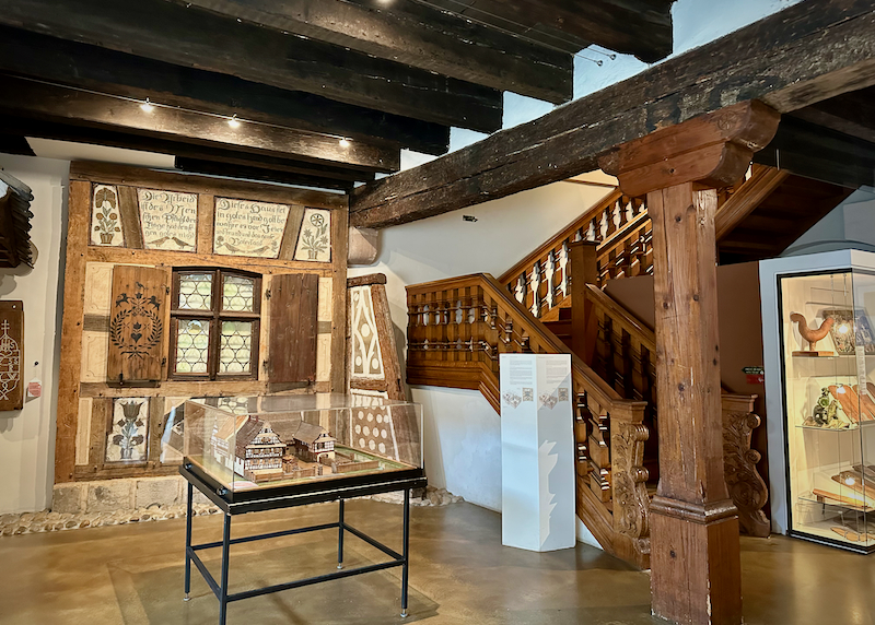 Small museum gallery room with timber framing and rustic decor