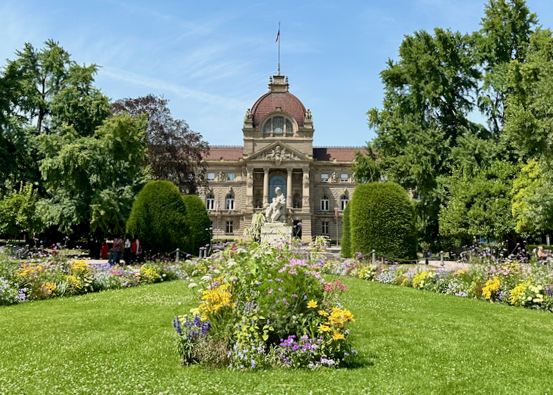 Elegant Neoclassical building with colorful gardens in front
