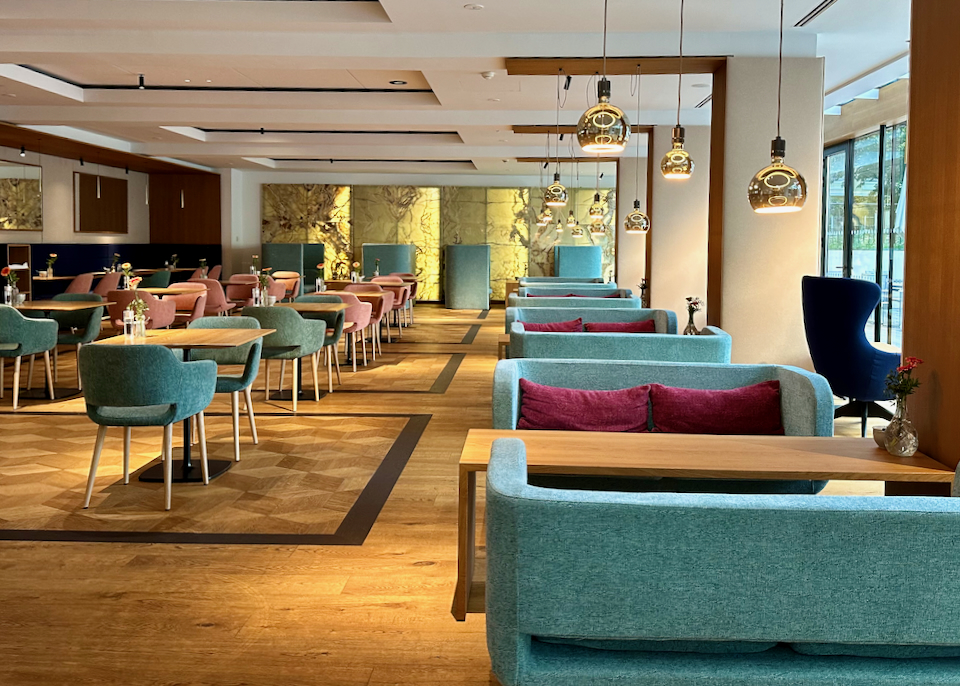 Bright hotel restaurant with modern couch seating in cheery jewel tones