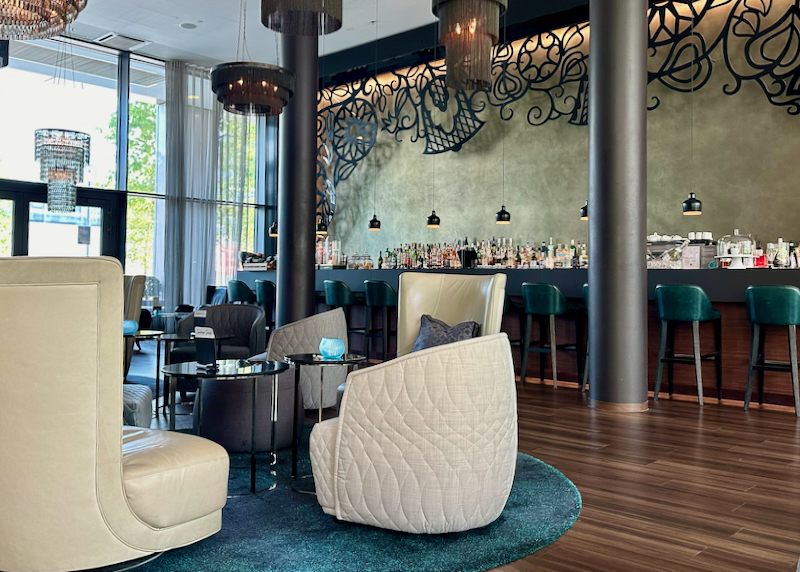 Hotel lobby with lounge chairs and a bar.