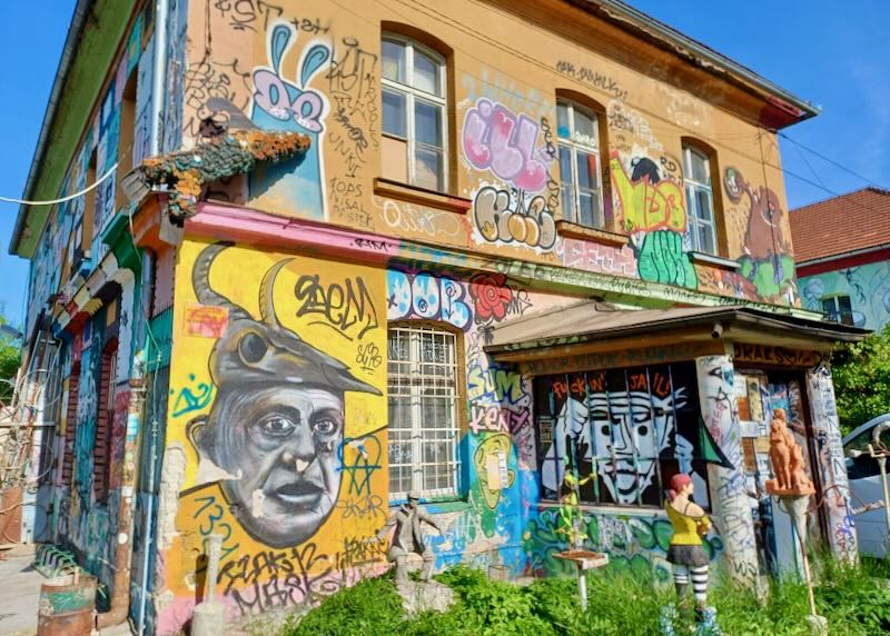 A graffitied building with bars on the windows looks closed but it's a cultural center.
