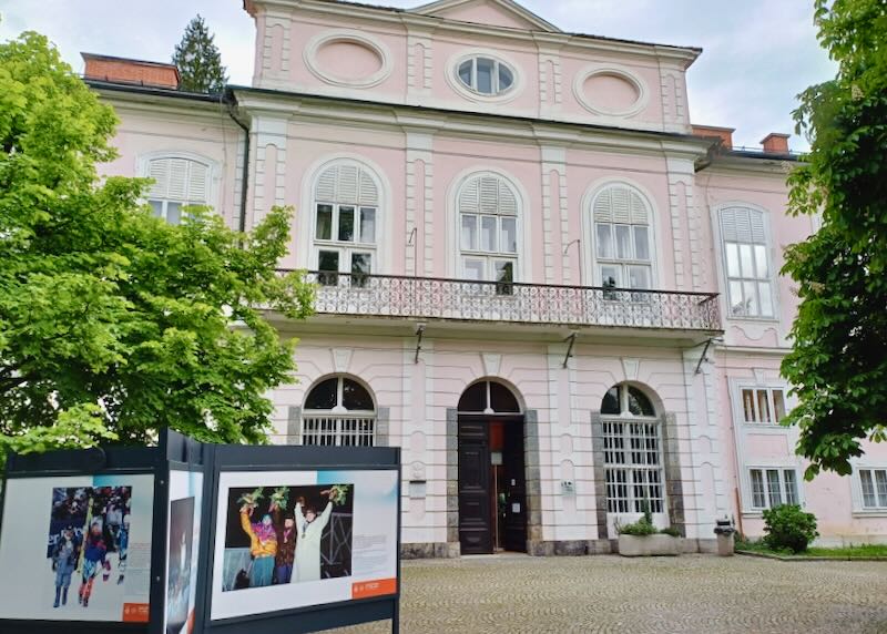 A pink painted three-story building.