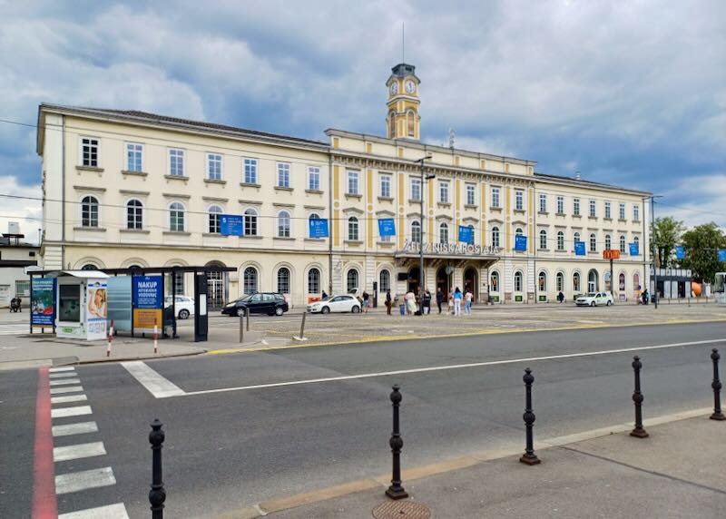 A long pale yellow building serves as a train station.