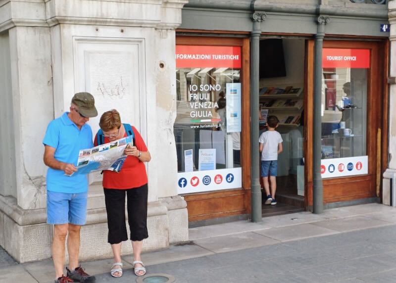 People view a map outside a tourist office.