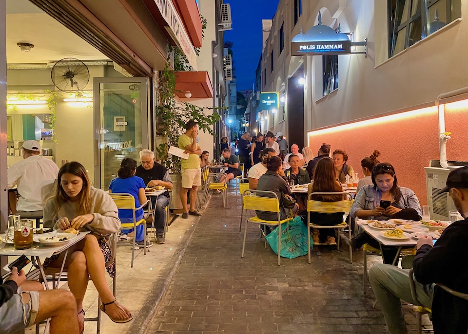 Outdoor dining tables on a pedestrian street in Athens.