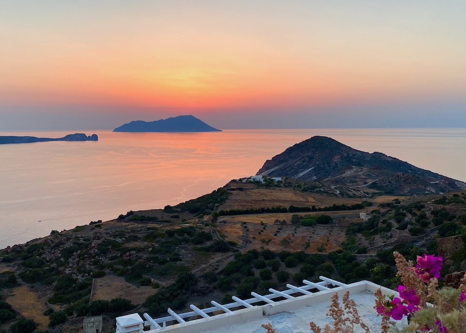 A sunset view from a hill in Milos facing the sea and islands.
