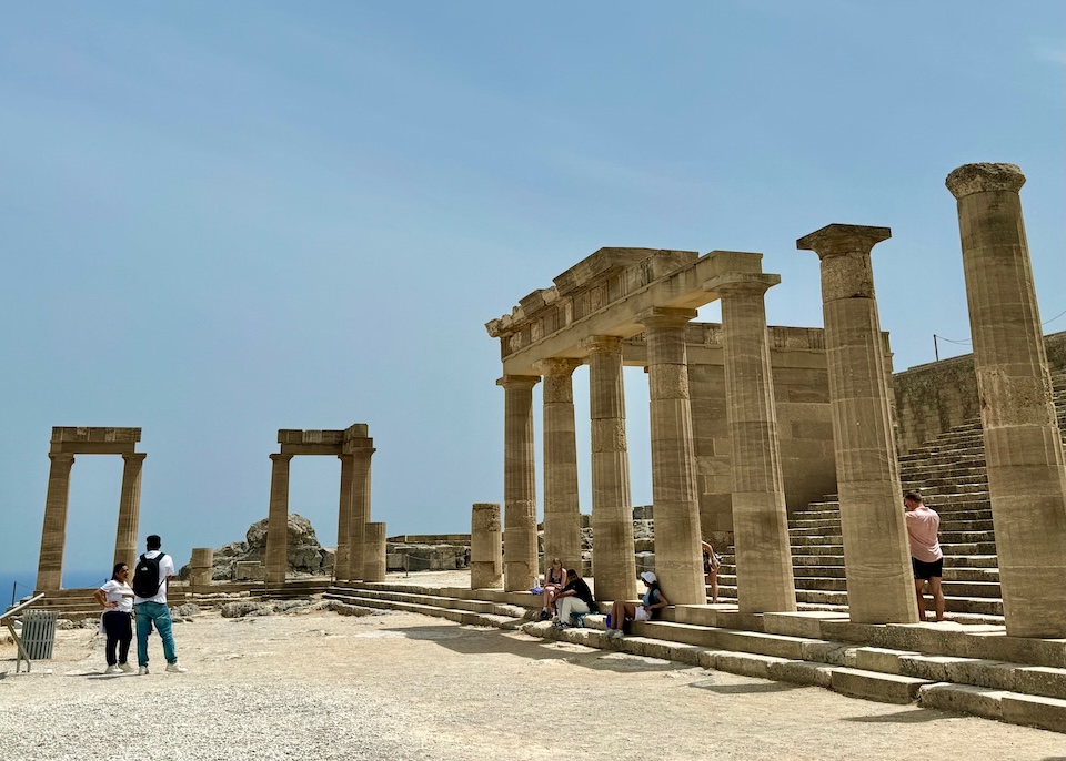 Ancient temple ruins wiht columns and staircases at the Lindos Acropolis in Rhodes.