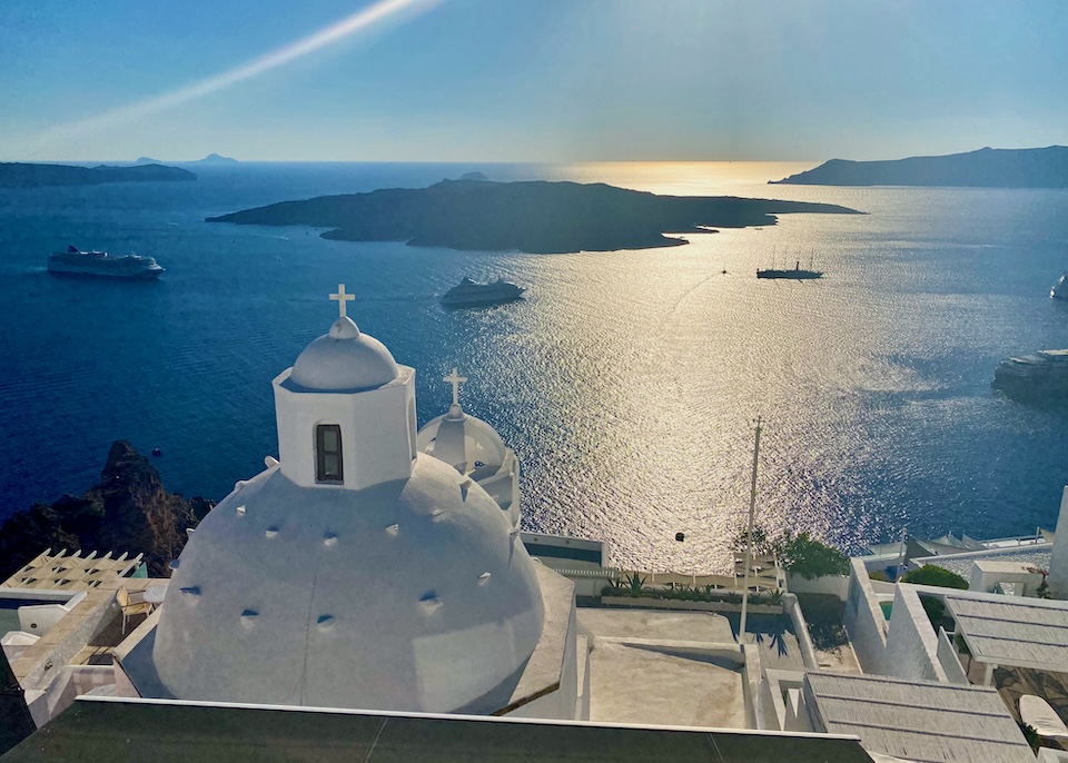 Sunset view over a church dome in Fira, Santorini.