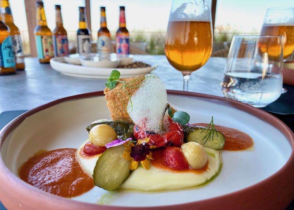 A gourmet vegetable dish paired with craft beer.
