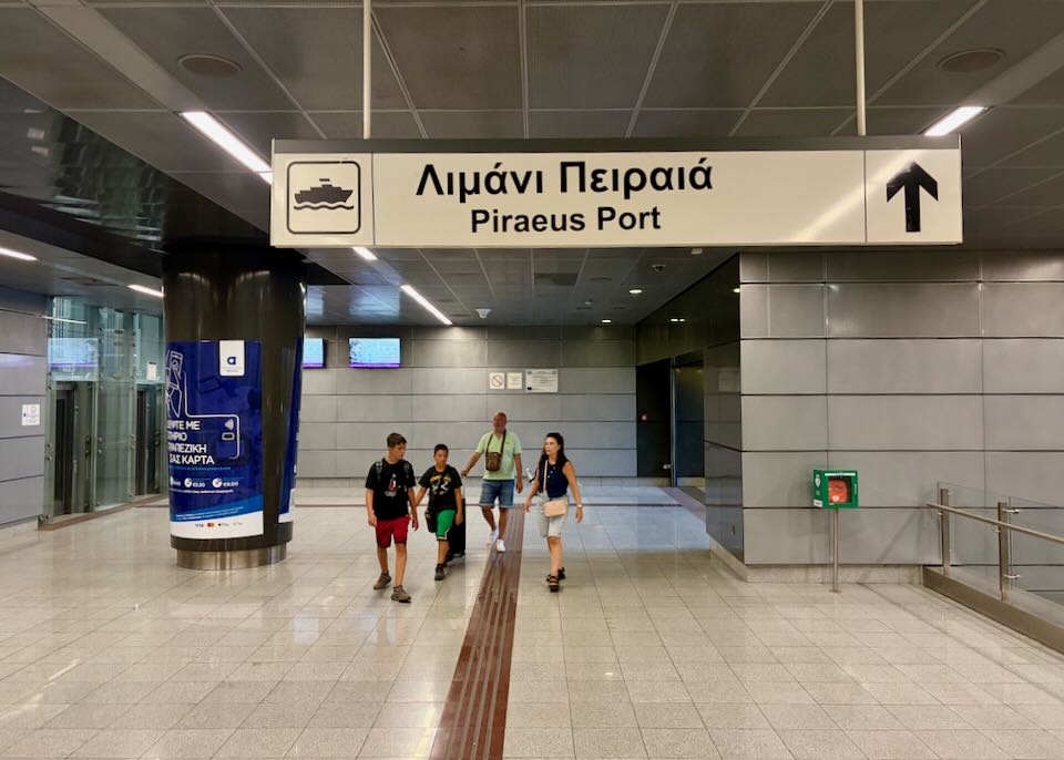 Metro signs at Syntagma station showing the direction toward Piraeus.